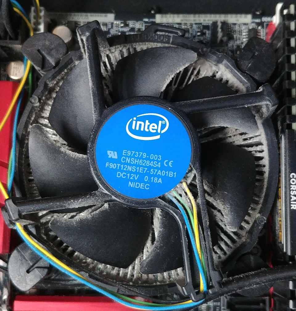 A dusty Intel stock heatsink in a cramped case